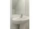 Close up on a stylish pedestal sink with a modern faucet and large mirror in the bathroom at 8577 S 253Rd Dr, Buckeye, AZ 85326