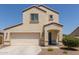 Two-story stucco home with a two-car garage, covered porch, and xeriscaped front yard at 8577 S 253Rd Dr, Buckeye, AZ 85326
