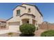 Two-story stucco home with a two-car garage, covered porch, and xeriscaped front yard at 8577 S 253Rd Dr, Buckeye, AZ 85326