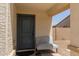 Cozy covered front porch with blue front door and seating space at 8577 S 253Rd Dr, Buckeye, AZ 85326