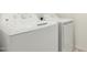 Close up of a new, front-loading white GE washer and dryer set in the laundry room at 8577 S 253Rd Dr, Buckeye, AZ 85326