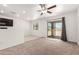 Spacious living room with ceiling fan and sliding glass doors leading to the backyard at 8577 S 253Rd Dr, Buckeye, AZ 85326