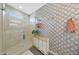Bathroom with a modern shower, a storage shelf, patterned wallpaper, and luxury finishes at 8683 S 165Th Ave, Goodyear, AZ 85338