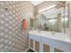 Modern bathroom with dual sinks, white cabinets, decorative wallpaper, and a spacious shower at 8683 S 165Th Ave, Goodyear, AZ 85338