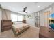 Well-lit bedroom featuring a ceiling fan, warm carpet, and large window with light sheer curtains at 8683 S 165Th Ave, Goodyear, AZ 85338