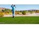 Scenic golf course view with lush green fairway and player teeing off against a desert landscape backdrop at 8683 S 165Th Ave, Goodyear, AZ 85338