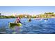 People kayaking on a lake with palm trees, fountains, and mountains in the background at 8683 S 165Th Ave, Goodyear, AZ 85338