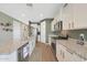 Charming kitchen with stainless steel appliances, granite countertops, and white cabinets and a green accent wall at 8683 S 165Th Ave, Goodyear, AZ 85338
