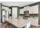 Well-lit kitchen features an island with bar seating, granite countertops, and stainless steel appliances at 8683 S 165Th Ave, Goodyear, AZ 85338