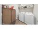 Laundry room with a front-load washer and dryer, shelving, and a cabinet at 8683 S 165Th Ave, Goodyear, AZ 85338
