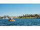 People enjoying a pedal boat ride on the community lake with water fountains and palm trees at 8683 S 165Th Ave, Goodyear, AZ 85338