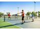 People enjoying a game of pickleball on an outdoor court with sports field lighting at 8683 S 165Th Ave, Goodyear, AZ 85338