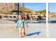 A young girl enjoys the splash pad, showcasing the community's fun water features for children at 8683 S 165Th Ave, Goodyear, AZ 85338