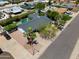 Aerial view showcases property with pool, covered patio, mature trees, and gravel landscaping at 8732 E Sandalwood Dr, Scottsdale, AZ 85250