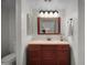Comfortable bathroom with a single sink vanity and a framed mirror and overhead lighting at 8732 E Sandalwood Dr, Scottsdale, AZ 85250