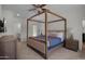 Charming primary bedroom features a canopy bed, carpeted floors, and access to the ensuite bathroom at 8732 E Sandalwood Dr, Scottsdale, AZ 85250