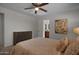 Cozy bedroom features a ceiling fan, dresser, neutral walls, and doorway to an ensuite bathroom at 8732 E Sandalwood Dr, Scottsdale, AZ 85250