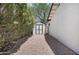 White storage shed with grey doors on a gravel path next to the house and green foliage at 8732 E Sandalwood Dr, Scottsdale, AZ 85250