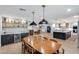 Open-concept dining and kitchen area with stylish lighting fixtures and a bar area at 9005 W Villa Chula St, Peoria, AZ 85383