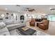 Open-concept living area with a sofa, recliners, and a view into the modern kitchen at 9005 W Villa Chula St, Peoria, AZ 85383