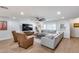 Inviting living room with a large sectional, leather chairs, and a modern entertainment center at 9005 W Villa Chula St, Peoria, AZ 85383