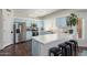 Well-lit kitchen boasts blue cabinets, stainless steel appliances, an island with seating, and hardwood floors at 10723 N 118Th Way, Scottsdale, AZ 85259
