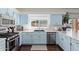 Modern kitchen with stainless steel appliances, light blue cabinets, and a window overlooking the backyard at 10723 N 118Th Way, Scottsdale, AZ 85259