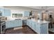 Open kitchen with blue cabinets, stainless steel appliances, long countertop, and view to the pool area at 10723 N 118Th Way, Scottsdale, AZ 85259