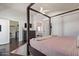 Large main bedroom with a canopy bed, dark wood floors, and access to the bathroom and closet at 10723 N 118Th Way, Scottsdale, AZ 85259