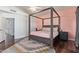 Cozy main bedroom with a canopy bed, soft pink accents, and views of a hallway and staircase at 10723 N 118Th Way, Scottsdale, AZ 85259