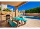 Covered patio features a picnic table for outdoor dining and entertaining near backyard pool at 10723 N 118Th Way, Scottsdale, AZ 85259