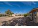 Backyard view of the property featuring mature trees and gravel landscaping at 12831 W Maplewood Dr, Sun City West, AZ 85375