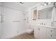 Accessible bathroom featuring an accessible shower with grab bars, white vanity, and bright lighting at 12831 W Maplewood Dr, Sun City West, AZ 85375