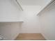 Walk-in closet with built-in shelving, bright lighting, and wood flooring at 12831 W Maplewood Dr, Sun City West, AZ 85375