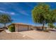 This charming home features a two-car garage, easy desert landscaping, and a shade tree in the front yard at 12831 W Maplewood Dr, Sun City West, AZ 85375