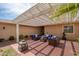 This shady covered patio offers seating, desert landscaping, and a stylish pergola perfect for entertaining at 12831 W Maplewood Dr, Sun City West, AZ 85375