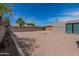 Large gravel backyard with fence, a detached garage, and a clear blue sky at 1322 W Flower St, Phoenix, AZ 85013
