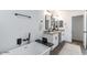 Modern bathroom featuring a freestanding tub, double vanity with granite counters, and stylish black fixtures at 1322 W Flower St, Phoenix, AZ 85013