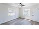Bright bedroom with wood-look tile flooring, two windows providing natural light, and a ceiling fan at 1322 W Flower St, Phoenix, AZ 85013