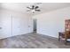 Bright bedroom with wood-look tile flooring, neutral walls, ceiling fan, and closet with sliding doors at 1322 W Flower St, Phoenix, AZ 85013