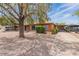 Charming single-story brick home with a mature tree, gravel landscaping, and covered parking at 1322 W Flower St, Phoenix, AZ 85013