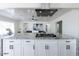 Open kitchen island with a cooktop, granite countertop, and white cabinets with black handles at 1322 W Flower St, Phoenix, AZ 85013