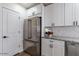 Beautiful kitchen with stainless refrigerator, white cabinets with black hardware, and herringbone backsplash at 1322 W Flower St, Phoenix, AZ 85013