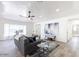 Bright living room with a gray couch, area rug, ceiling fan, and hardwood floors at 1322 W Flower St, Phoenix, AZ 85013