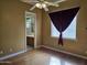 Bedroom with wood floors, fan, window, and connecting door to the bathroom at 14380 W Monte Vista Rd, Goodyear, AZ 85395