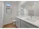 Bathroom with a double sink vanity, gray cabinets, and a large mirror at 14789 W Lariat Ln, Surprise, AZ 85387