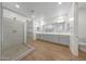 Modern bathroom featuring a glass shower, double sink vanity, and wood-look flooring at 14789 W Lariat Ln, Surprise, AZ 85387