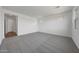 Large bedroom featuring neutral carpet, two windows, and an interior door at 14789 W Lariat Ln, Surprise, AZ 85387