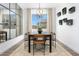 Modern dining room with large windows, contemporary lighting, and seating for eight at 14789 W Lariat Ln, Surprise, AZ 85387