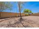 Large backyard featuring desert landscaping, a brick wall, and shade trees against a clear blue sky at 1520 N Milly Pl, Casa Grande, AZ 85122
